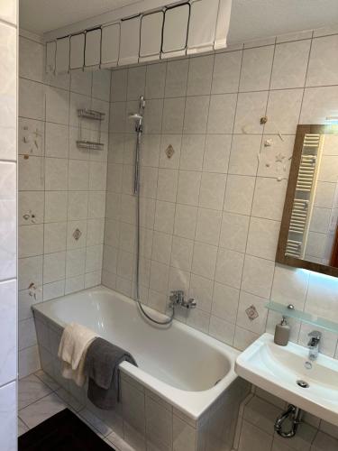 a white bathroom with a tub and a sink at Gasthaus Wini in Wanzleben