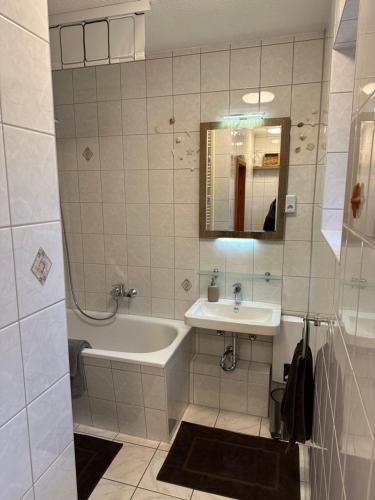 a bathroom with a tub and a sink and a mirror at Gasthaus Wini in Wanzleben