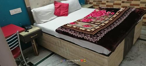 a bed with white sheets and red pillows on it at HOTEL NEW APPLE ROSE in Chandīgarh