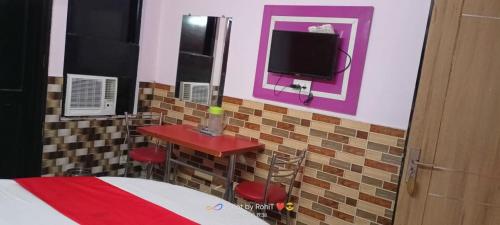 a bedroom with a bed and a tv on a wall at HOTEL NEW APPLE ROSE in Chandīgarh