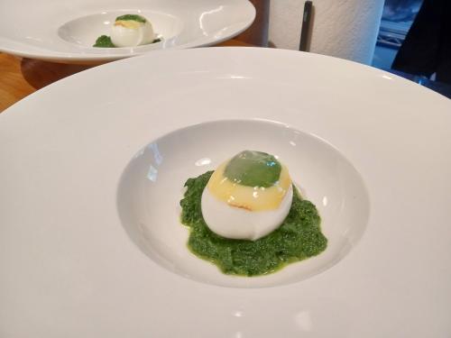 a white plate with an egg on top of green sauce at La maison de l'île d'Orléans -- déjeuner gastronomique à l'aveugle in Saint-Jean