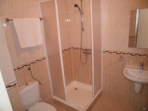 a bathroom with a shower and a toilet and a sink at EUROPA Guest House in Kiten