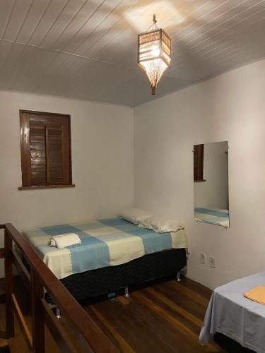 a bedroom with two beds and a chandelier at Pousada Kalango in Barra Grande