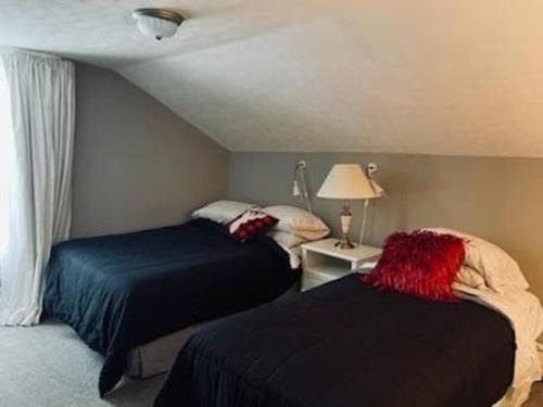 1 dormitorio con 2 camas, lámpara y ventana en Close to Town, en Ellicottville