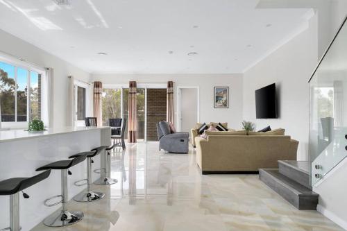 a living room with a couch and a table at Large Family Home with plenty of amenities in Campbelltown
