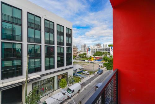 an apartment balcony with a red wall and buildings at Comfortable Apartment in Charming Wynwood in Miami