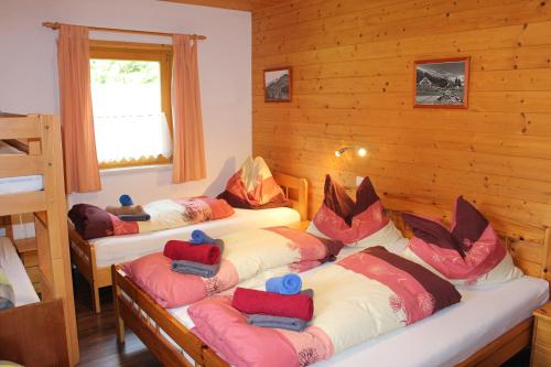 um quarto com três camas num chalé de madeira em Murtalhütte em Muhr