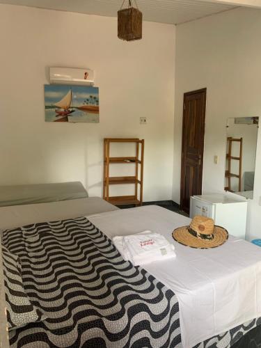 a room with a bed with a hat on it at Pousada Kalango in Barra Grande