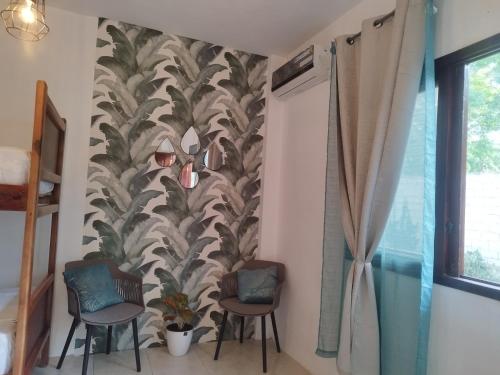 a room with two chairs and a wall with a mural at Palmendros Hosteria in Montañita