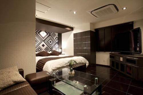a hotel room with two beds and a glass table at Hotel Alfa Kyoto in Kyoto