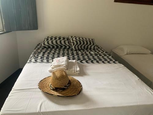 a hat and towels sitting on a bed at Pousada Kalango in Barra Grande