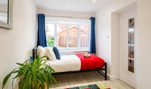 a bedroom with a bed with blue curtains and a window at Beautiful House in South Cambridge, 14-Min Drive to the City Centre, Free Parking, No Sofabeds, Sleeps 6 in Cambridge