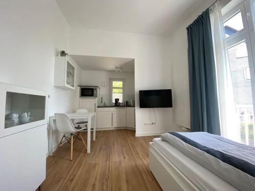 a bedroom with a bed and a desk and a kitchen at Apartment Nr. 2 Bad Laasphe Altstadt in Bad Laasphe