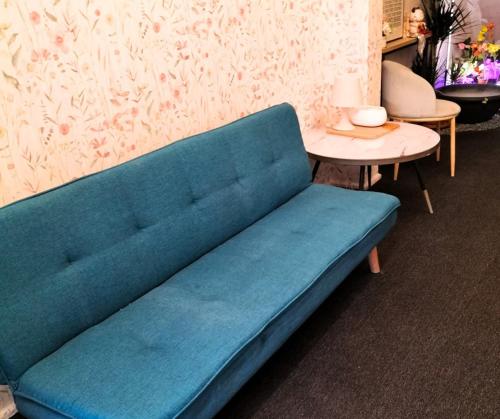 a blue couch in a room with a table at Le Melur Single Bed in George Town