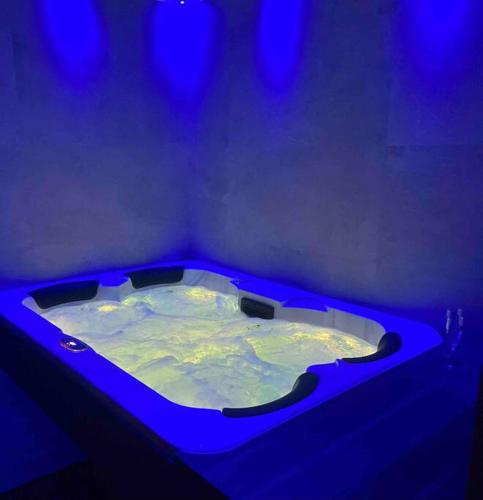 a hot tub in a room with blue lights at Appartement jacuzzi hammam in Francheville