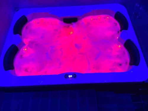 a red bath tub filled with lots of pink liquid at Appartement jacuzzi hammam in Francheville