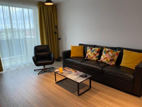 un soggiorno con divano nero e sedia di BrasoVista - PAJ Premium Apartments in URBAN Plaza a Braşov