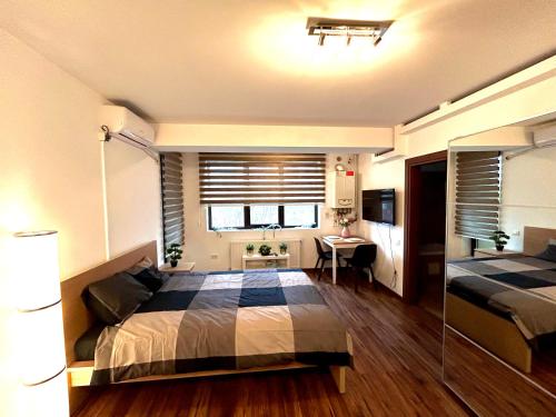a bedroom with two beds and a table and a desk at Cozy Apartment with Self Check-in near Promenada Mall and Verdi Park in Bucharest