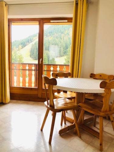 une table et des chaises dans une pièce avec une fenêtre dans l'établissement Appartement à la montagne (jusqu'à 6 personnes), à Le Biot