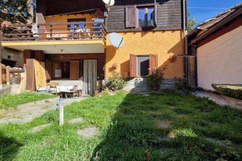 une maison avec une cour d'herbe devant elle dans l'établissement Fionisco - Giardino privato con vista sulle Alpi, à Brusson