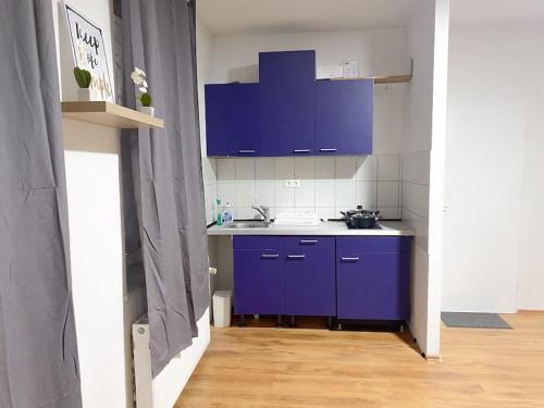 a kitchen with purple cabinets and a blue sink at Apartment in Gelsenkirchen - Gemütliche City-Suite in Gelsenkirchen