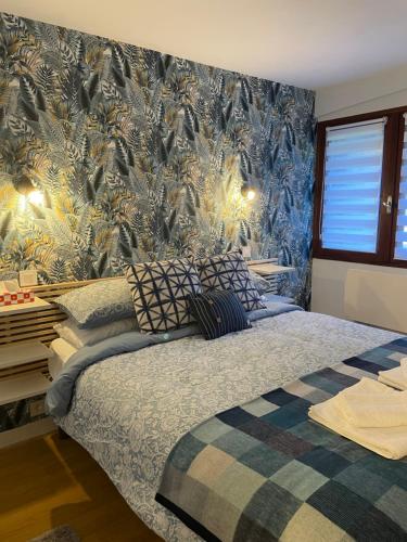 1 dormitorio con 1 cama con papel de pared azul y dorado en Vue du Gar, en Saléchan