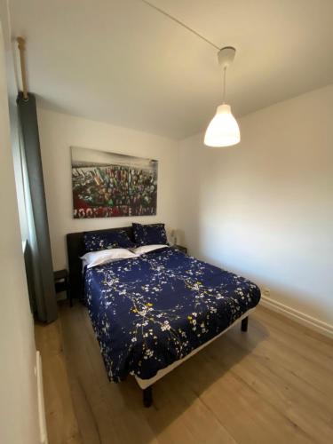 1 dormitorio con 1 cama y una pintura en la pared en Appartement Marceau Courbevoie, en Courbevoie