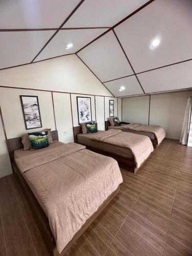 a room with three beds in a room at Villa Takasima Berastagi in Berastagi