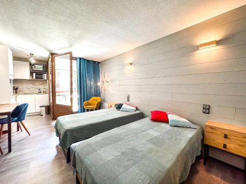 une chambre d'hôtel avec deux lits et une table dans l'établissement 1- Studio Brides-les-bains tout confort, à Brides-les-Bains