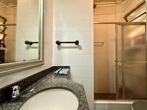 ein Bad mit einem Waschbecken und einer Dusche in der Unterkunft Ótimo Apartamento - 500m Praia Copacabana/RJ in Rio de Janeiro