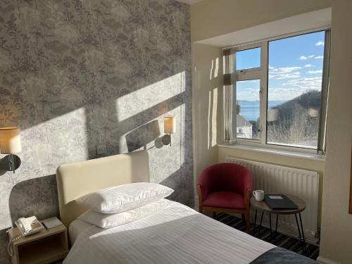 a hotel room with a bed and a window at Pandora Hotel in St Peter Port