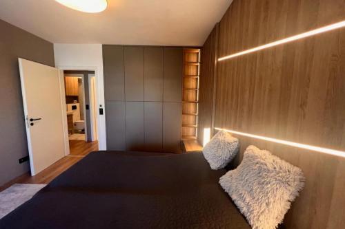 1 dormitorio con cama negra y pared de madera en Glamorous Apartment in Budapest, Hungary, en Budapest