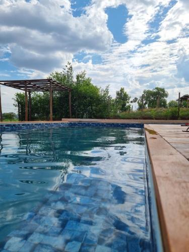 a swimming pool with a gazebo in the background at Chácara Lótus in Trindade