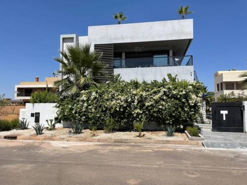 een witte struik voor een huis bij HAUT de villa contemporain sur golf securise in Marrakesh