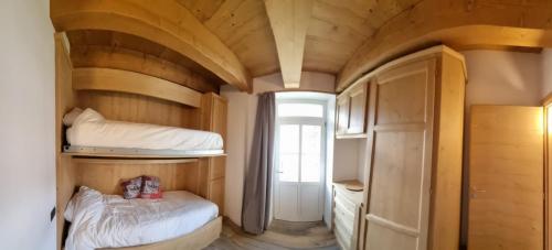 a small room with two bunk beds and a door at Appartamento Vale e Schena Cortina 4 posti letto in San Vito di Cadore