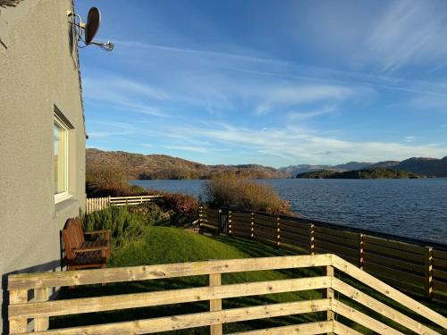 Loch Morar Private Suite في ماليغ: منزل مطل على جسم ماء
