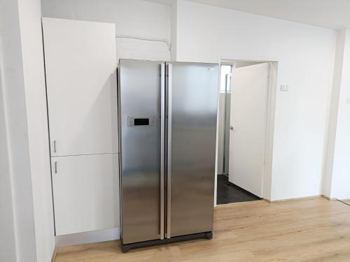 una nevera de acero inoxidable en una habitación con paredes blancas en Lovely Room 1Min Walk to Station with 55Inch TV, en Sídney