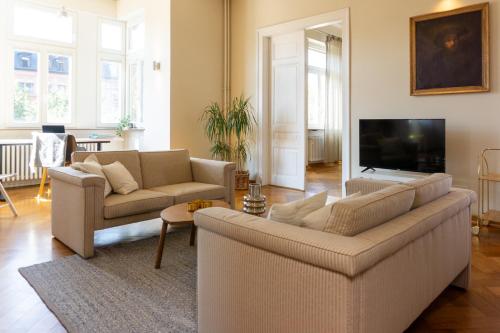 a living room with two couches and a flat screen tv at namastay! - Luxus mit Blick auf den Wasserturm in Mannheim
