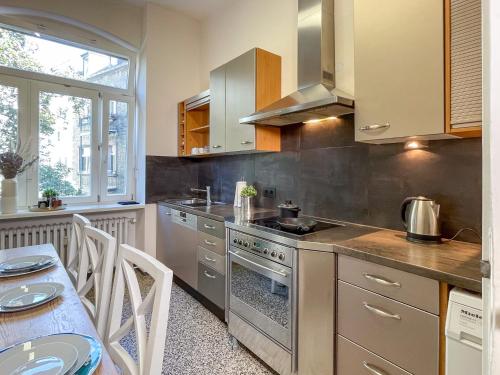 a kitchen with stainless steel appliances and a table with chairs at namastay! - Luxus mit Blick auf den Wasserturm in Mannheim