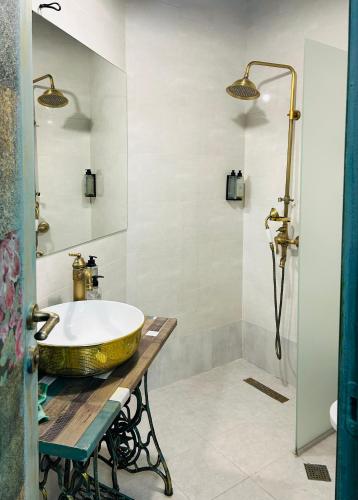 a bathroom with a gold sink and a shower at Hotel Zerta Old Tbilisi in Tbilisi City