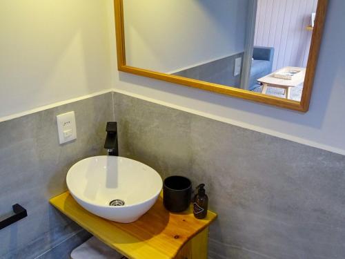 a bathroom with a white sink and a mirror at Il Tano Suites in Punta Del Diablo