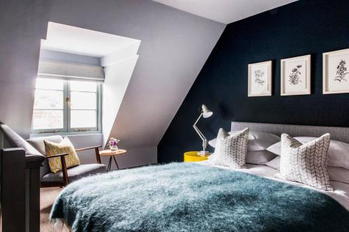 1 dormitorio con 1 cama grande y pared azul en The Loft House, en Hinton Charterhouse