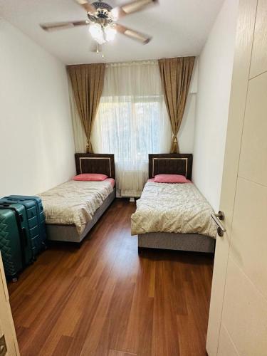 Duas camas num quarto com pisos em madeira e uma janela em إسطنبول em Esenyurt