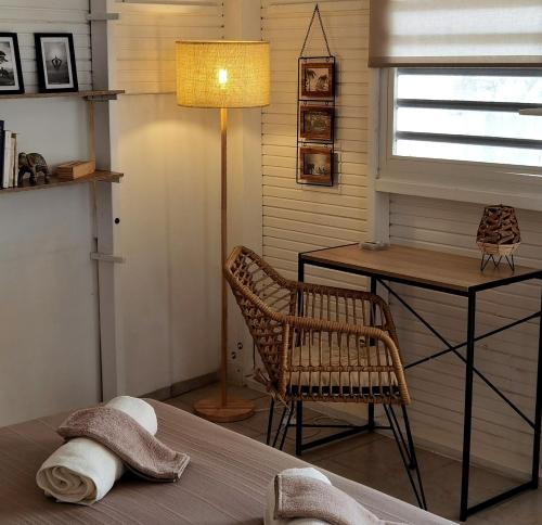 a bedroom with a table and a chair and a lamp at Coco Carib - Massage offert à partir de 3 nuits in Deshaies