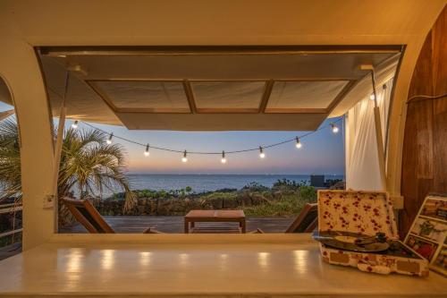 a view of the ocean from the living room of a house at BeachBoys - Retro Caravan AirStream in Jeju