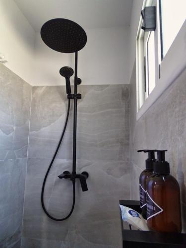 a shower in a bathroom with a bottle of soap at Il Tano Suites in Punta Del Diablo