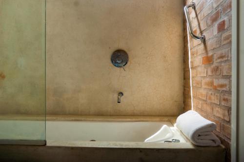 a bathroom with a bath tub with a glass wall at Il Tano Suites in Punta Del Diablo