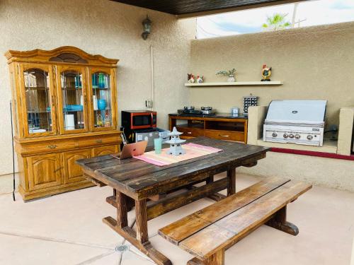 a kitchen with a wooden table and a bench at MI KASA HOT SPRINGS 420,Adults Only, Clothing Optional in Desert Hot Springs