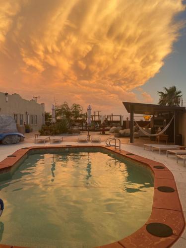 a large swimming pool with a cloudy sky in the background at MI KASA HOT SPRINGS 420,Adults Only, Clothing Optional in Desert Hot Springs