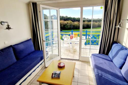 een woonkamer met blauwe banken en een tafel bij "SOLEIL DU GOLF" Appartement 5 personnes, vue golf, accès parc aquatique in Talmont